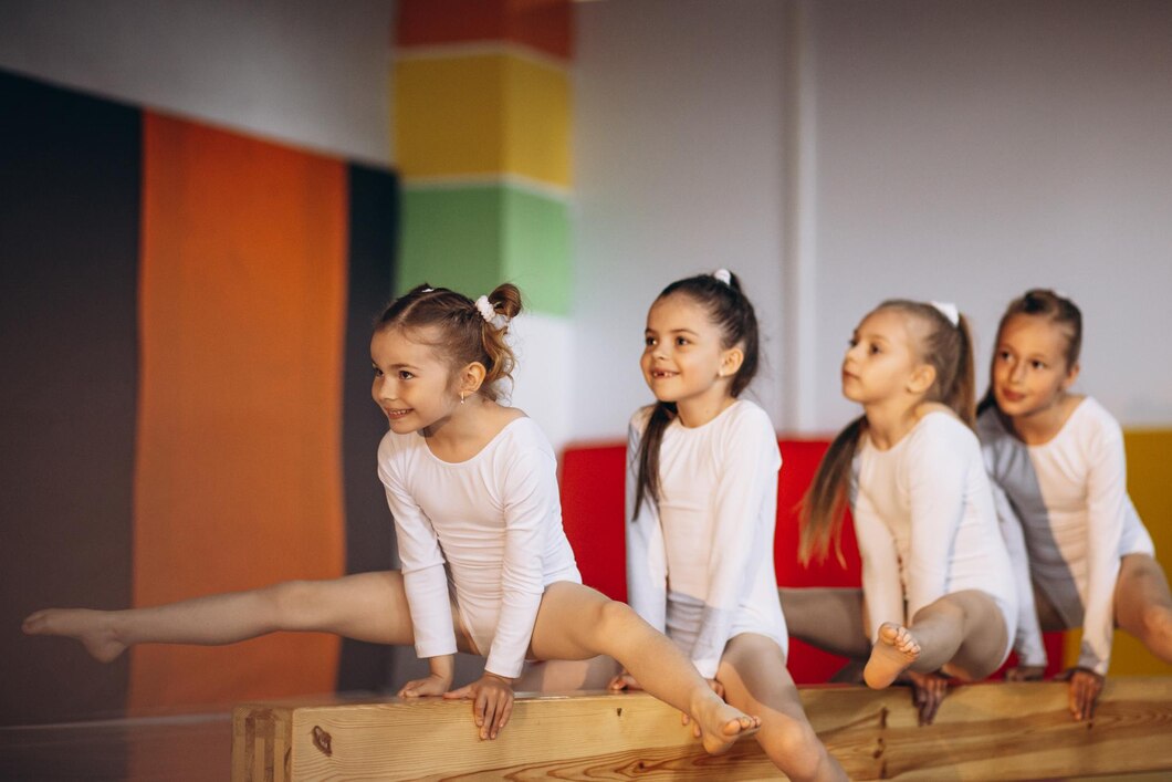 gruppe-von-maedchen-die-an-der-gymnastikschule-trainieren_1303-32169